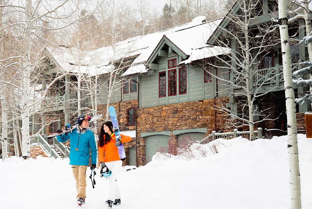 Winter home with couple carrying skis