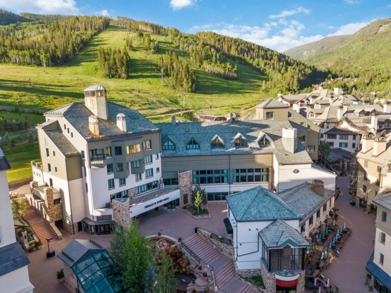 aerial view of a ski resort with green mountains surrounding