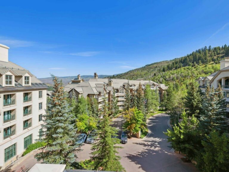 mountain lodging in Beaver creek with trees and a blue sky