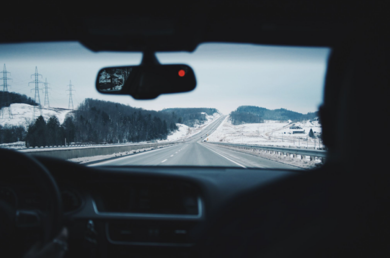 pov of windshield of a car looking out at snowy mountains