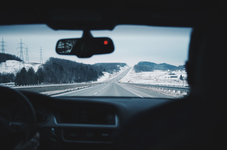pov of windshield of a car looking out at snowy mountains
